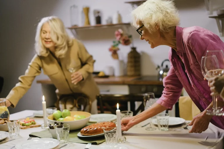 two ladies setting a table for dinner